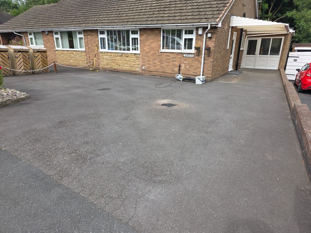 Faded, weathered grey tarmac driveway before sealing