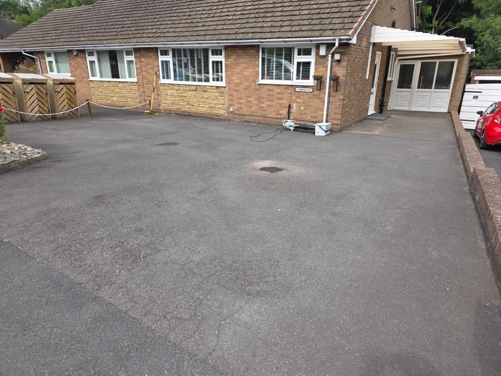 Faded, weathered grey tarmac driveway before sealing