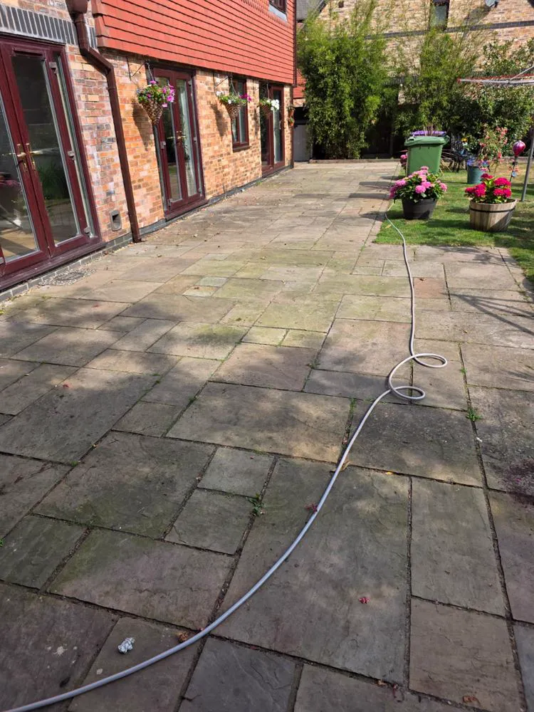 Dull, dirty sandstone patio slabs before pressure washing