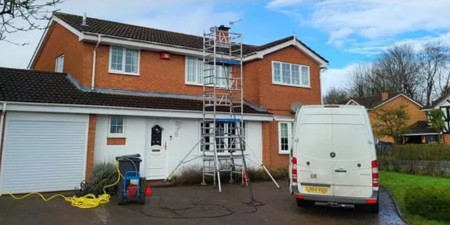 Aqua Glaze working on a detached house roof in Telford, scaffold tower up against the tiles and hoses run out across the drive