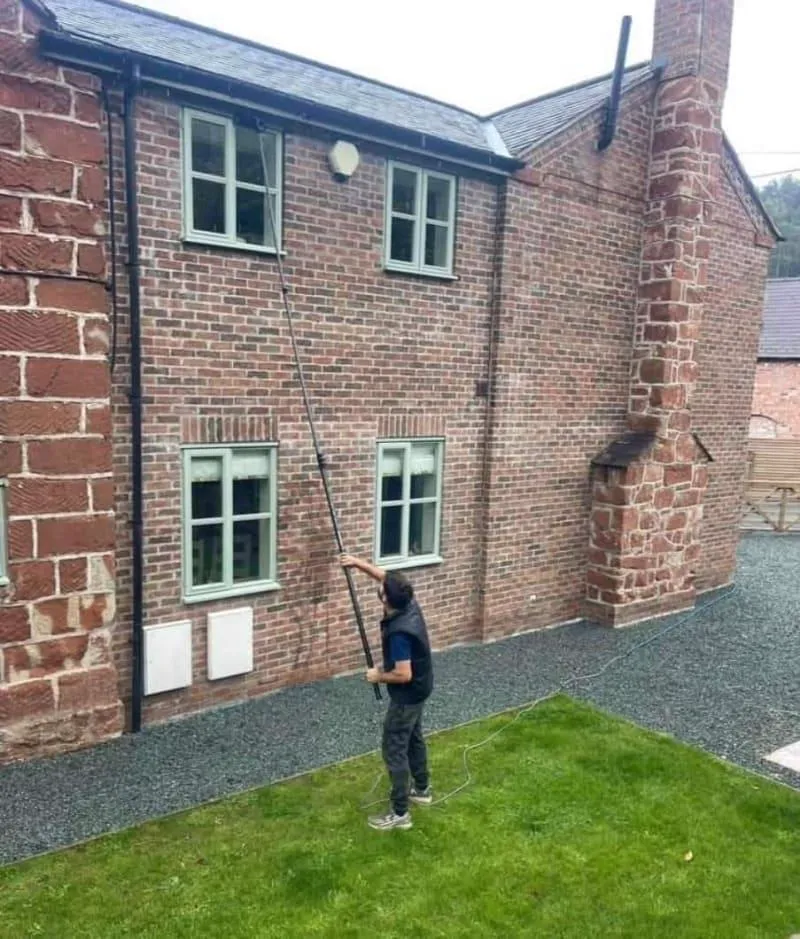 Water-fed pole cleaning an upstairs window in Telford, streak-free glass