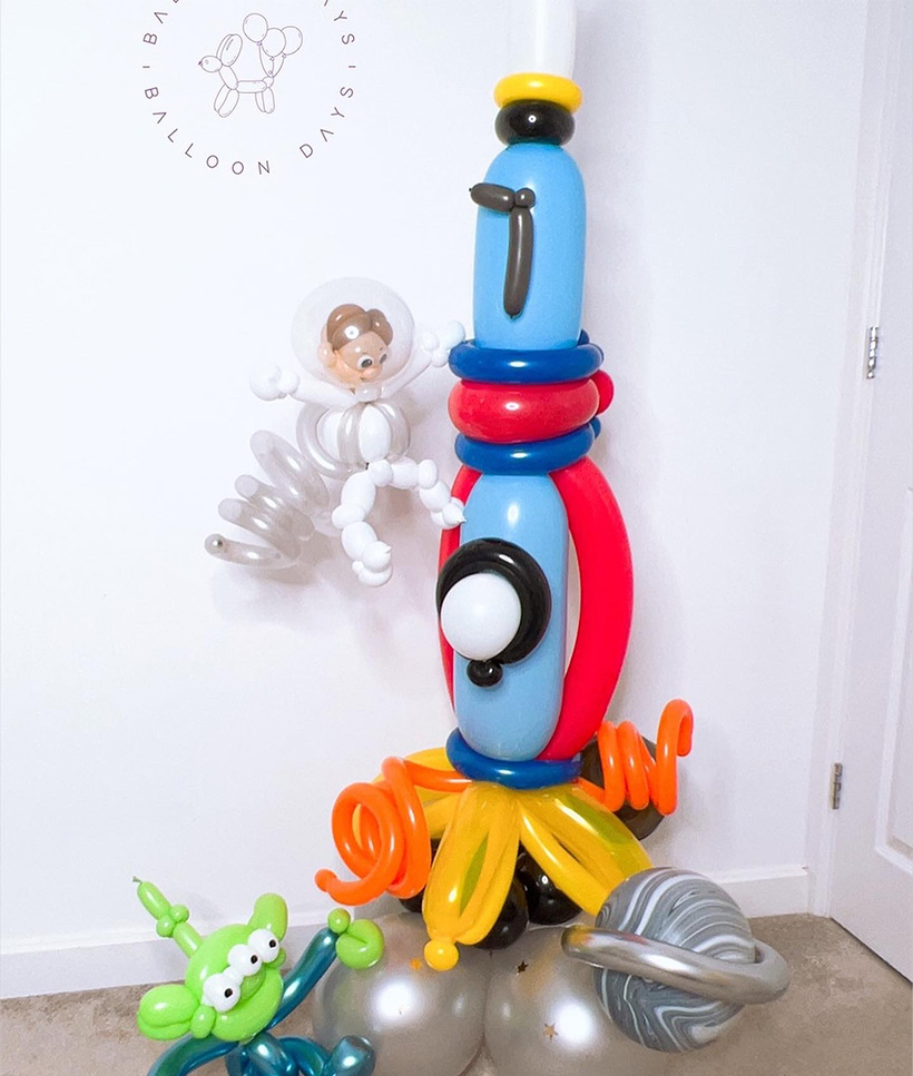 A red number two balloon stack with handmade character balloons for a toddler birthday