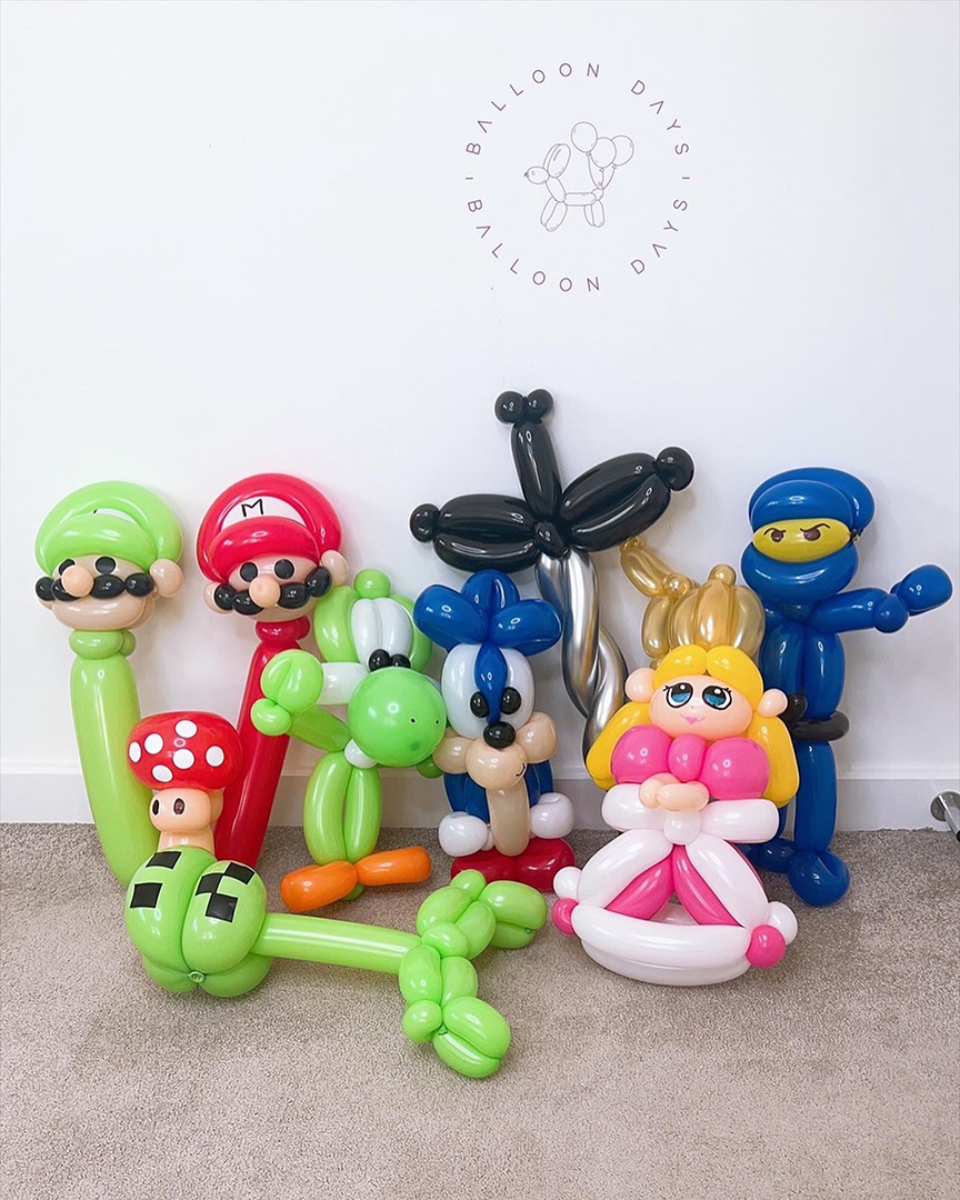 A collection of intricate character balloon sculptures twisted by hand, including Mario, Luigi, Yoshi, Sonic, a ninja and Princess Peach