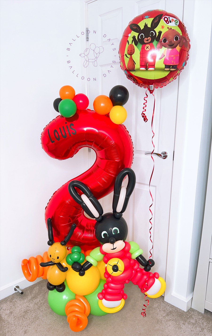 A personalised red number two balloon stack with handmade Bing and Flop characters for a toddler's birthday