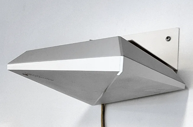 A white BAPLA bracket on a white wall holding an angular white Aerohive access point level beneath it, a yellow cable running down from the access point.