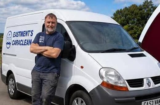 Brian Eastment standing with his arms folded beside the Eastment's Caraclean van, which carries the business name along the side.