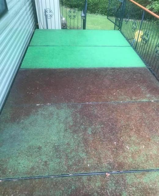 The artificial grass on a static caravan veranda before cleaning, stained dark red brown and green.