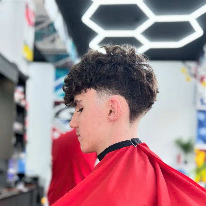 Textured curly top with a skin fade, fresh from the chair