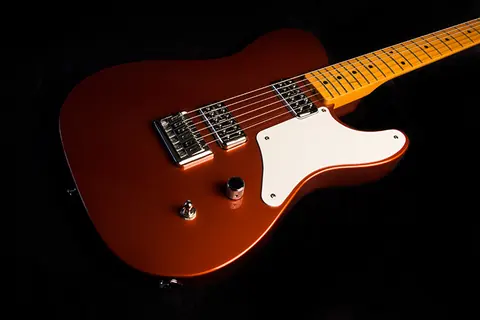 A copper metallic J. Davey Cabronita style Telecaster with a white pickguard, two humbuckers and a maple neck, photographed on black