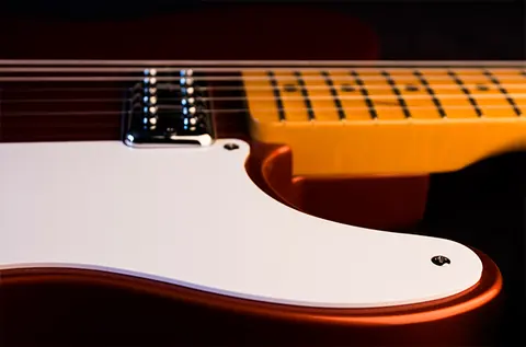 The edge of the Cabronita white pickguard where it meets the maple fingerboard