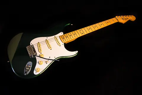 The racing green Stratocaster full length, body and maple neck, against black