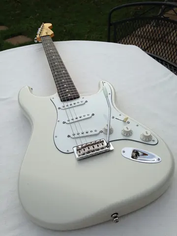 The white J. Davey Signature Series Stratocaster at an angle, showing the body contour and neck joint