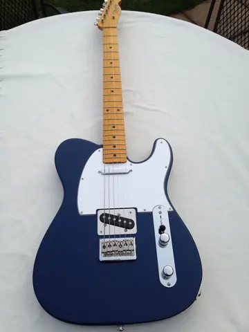The dark blue J. Davey Standard Series Telecaster laid flat, full body and maple neck
