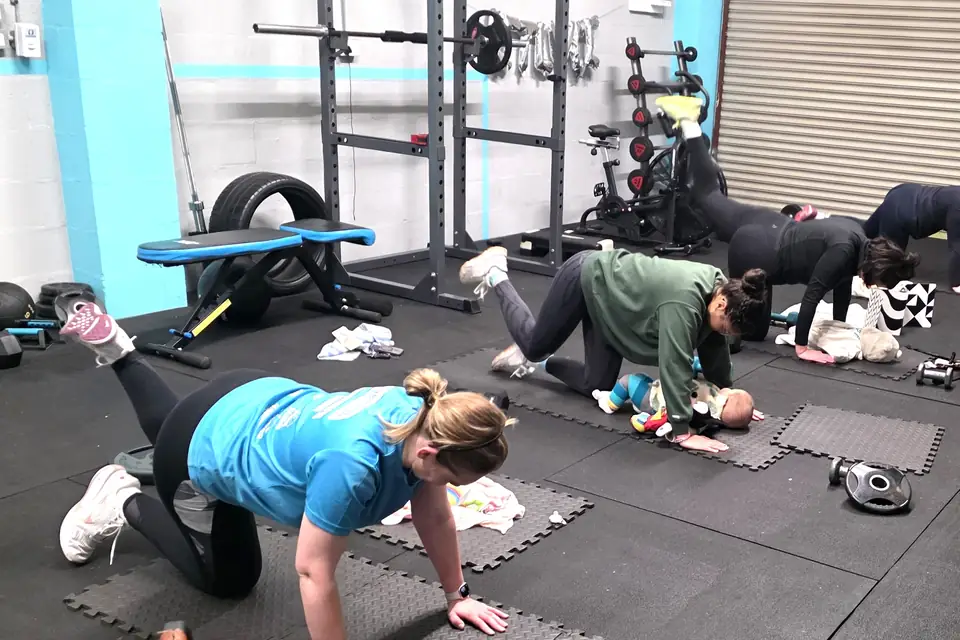 Mums training on mats in the Let Luce studio, with a baby on the mat beside them.