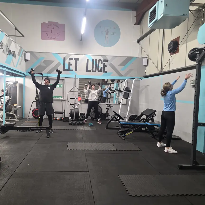 Three people training together in the Let Luce studio under the LET LUCE sign.