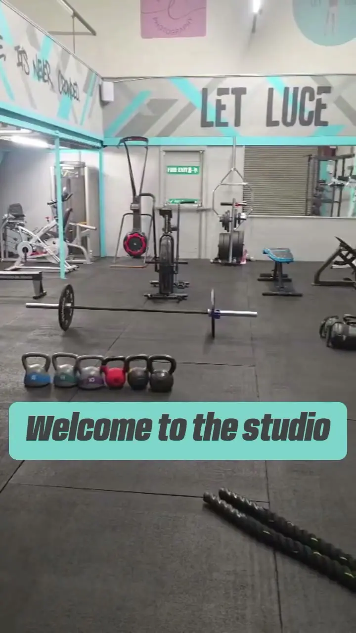The training floor at Unit 49 under the LET LUCE sign, with kettlebells lined up, a barbell and battle ropes on the rubber floor.