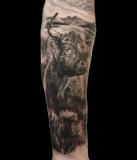 Wildlife and landscape scene in black and grey along the forearm