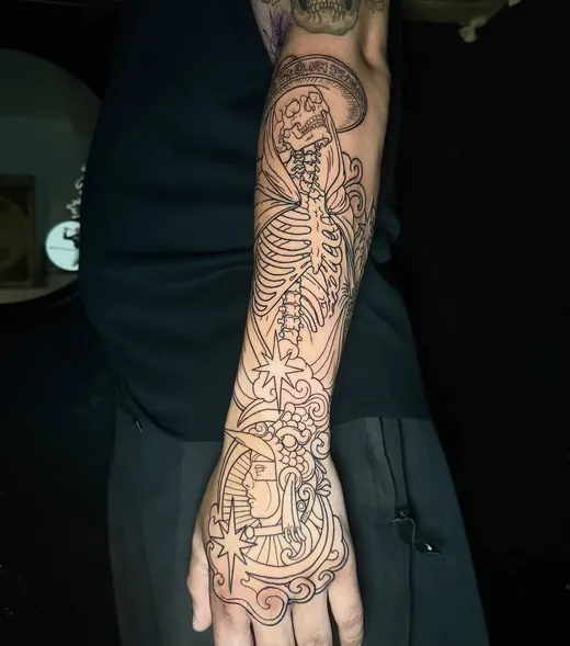 Fine ornamental linework in progress across the hand and forearm