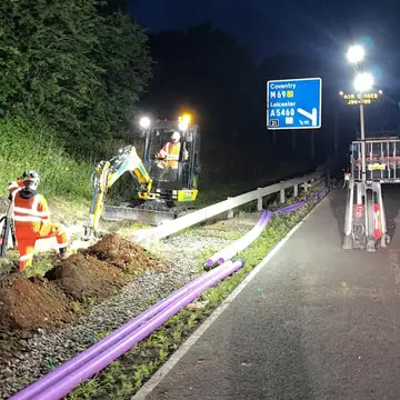 Night highways works on a slip road with mini excavator and ducting
