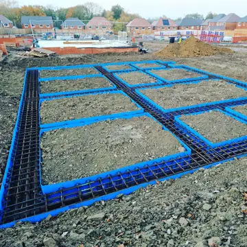 Reinforced raft foundation with rebar and blue formwork on a housing site