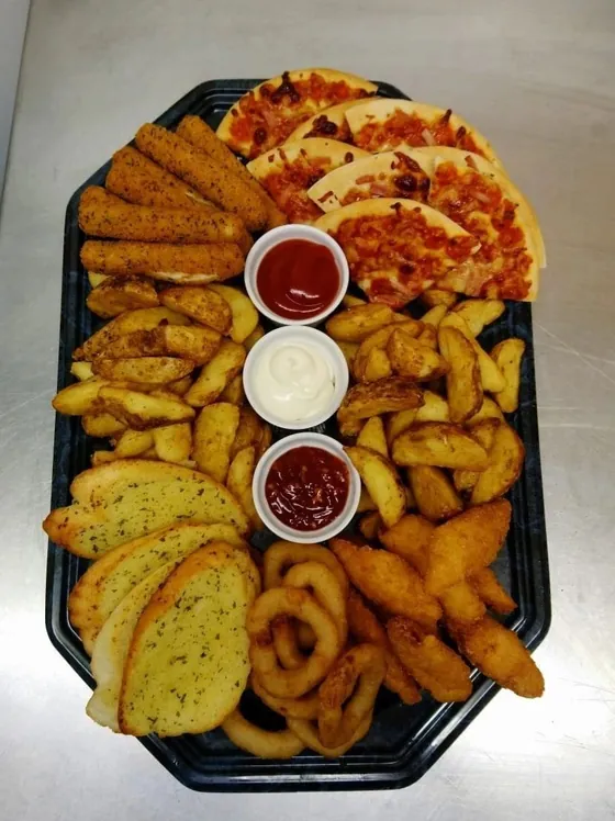 A large black platter fanned with garlic bread, curly fries and breaded bites, with three dip pots.