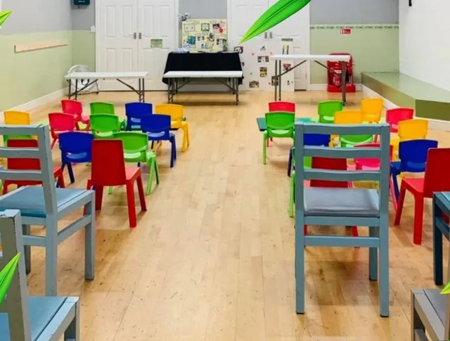 The Den laid out for a class, with small blue and red children's chairs and low tables.