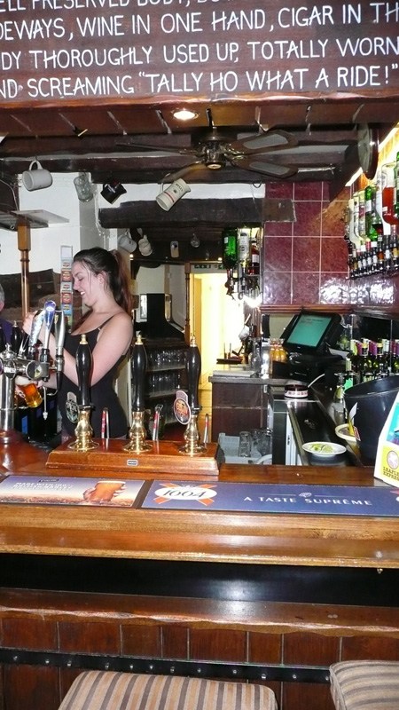 Behind the bar at the Robin Hood, hand pumps lined up beneath a beam