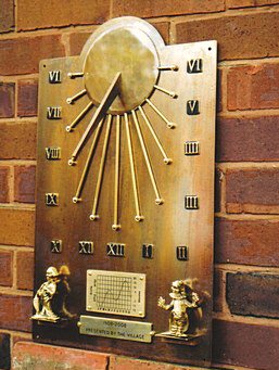 An Auguste wall dial fitted with an additional engraved inscription plate along the bottom edge of the backing plate, below the Equation of Time chart and between the two cast weather figures.