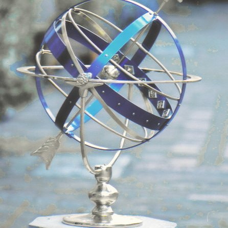 The Celeste armillary, its bright sky-blue anodized sphere held between Taurean horns in brass.