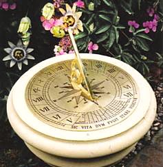 The Classic brass sundial on its pale stone pedestal among passion flowers, shown as the smaller catalogue view of the same photograph.