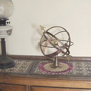 A Vesta armillary placed indoors as an ornament in a room setting.