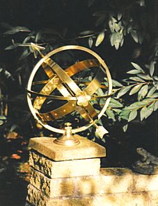 A Mandala armillary standing in a sunny corner beside a wall.