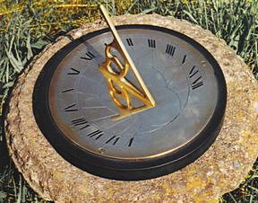 The Presentation sundial set into a rough stone block on grass, the smaller catalogue view of the same photograph.