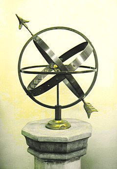 A weathered brass Solstice armillary standing on display in the showroom.