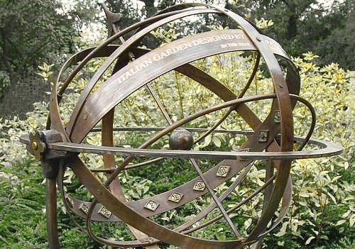A close view of an engraved bronze Taurus armillary, with an inscription running along the outside of the equatorial band and the signs of the Zodiac engraved below it.