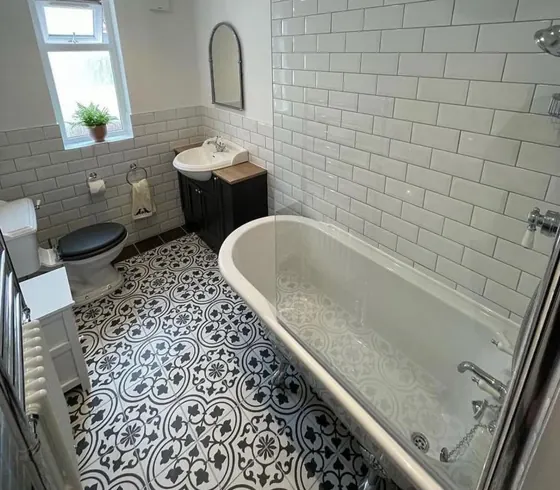 Traditional bathroom with a patterned floor, white metro tiling, basin and bath