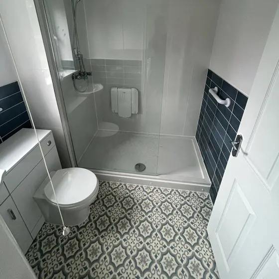 Shower room with a low tray, patterned floor tiles and a dark accent wall