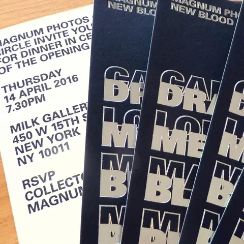 A navy invitation printed for Magnum Photos New Blood, with large type picked out in a raised metallic finish catching the light.