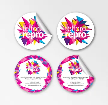 Four round telford repro stickers on a pale grey surface, two plain white with the magenta shard logo and two with a confetti border printed with the address, phone number, email and website. Two have a peeling corner.