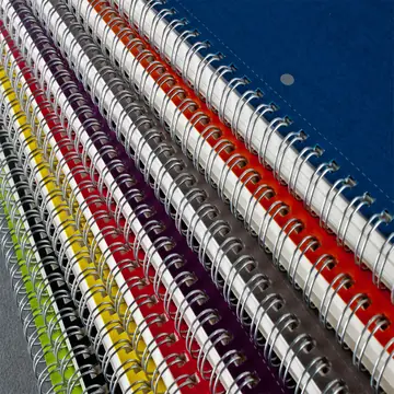A close up stack of wire bound documents with red, yellow, blue and black wire spines lined up.
