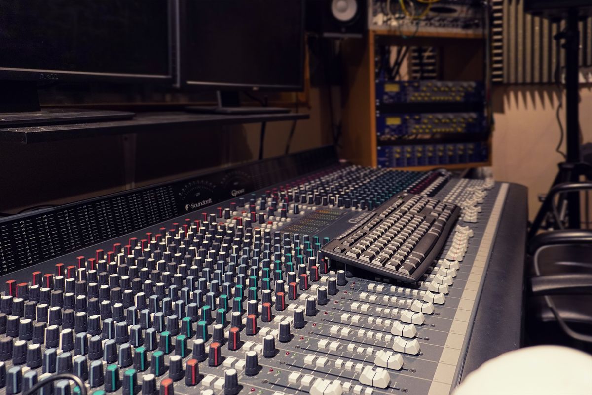 A Soundcraft Ghost mixing console covered in coloured knobs and faders in the recording studio