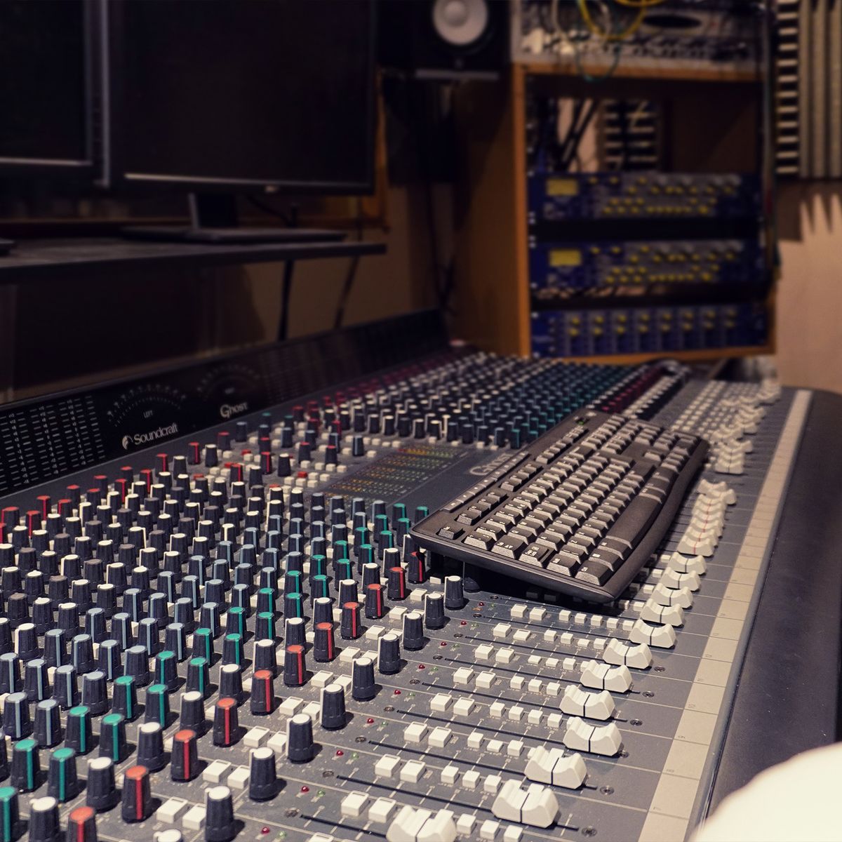 Angled view down the Soundcraft Ghost console with racks of outboard behind