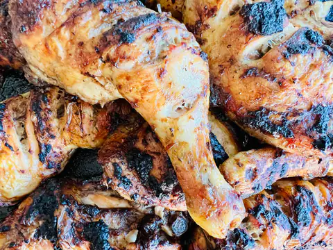 Chargrilled barbecue chicken drumsticks piled on a tray