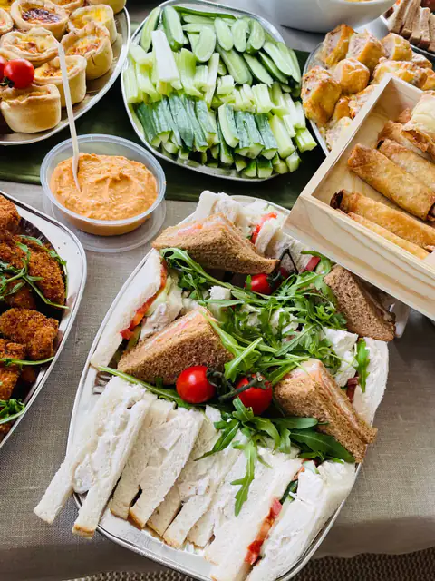 Buffet sandwiches with rocket and cherry tomatoes, served with dips and crudités