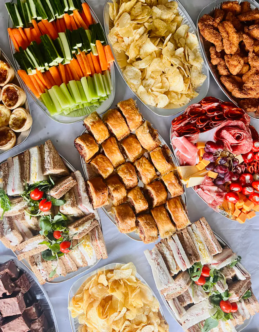 A full buffet spread of sandwiches, crudités, crisps, cured meats and cheese