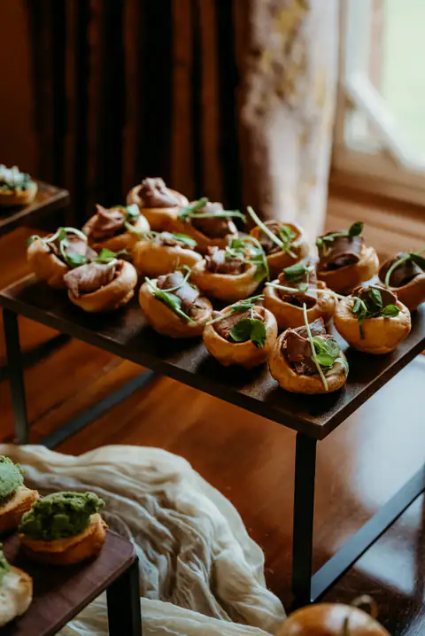 Close-up of filled canapé tartlets garnished with herbs