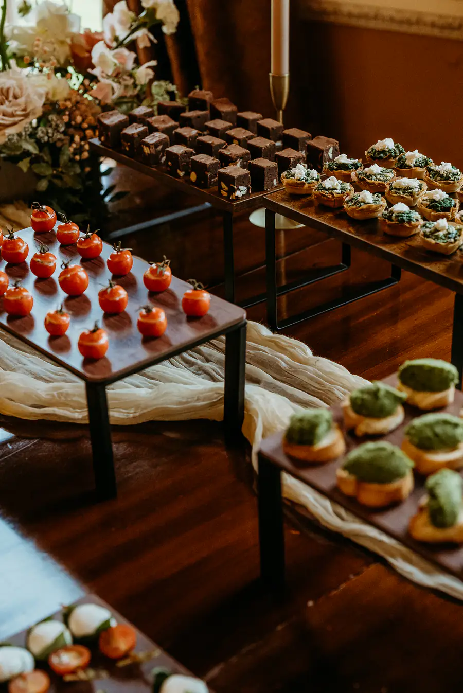 Cherry tomato and guacamole canapés lined up on black risers