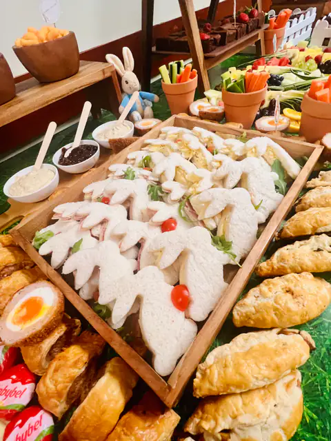 Bunny-shaped sandwiches and pastries laid out for a children’s party