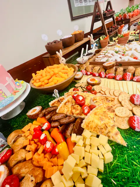 A children’s party grazer with fruit, cheese, sandwiches and pastel decorations