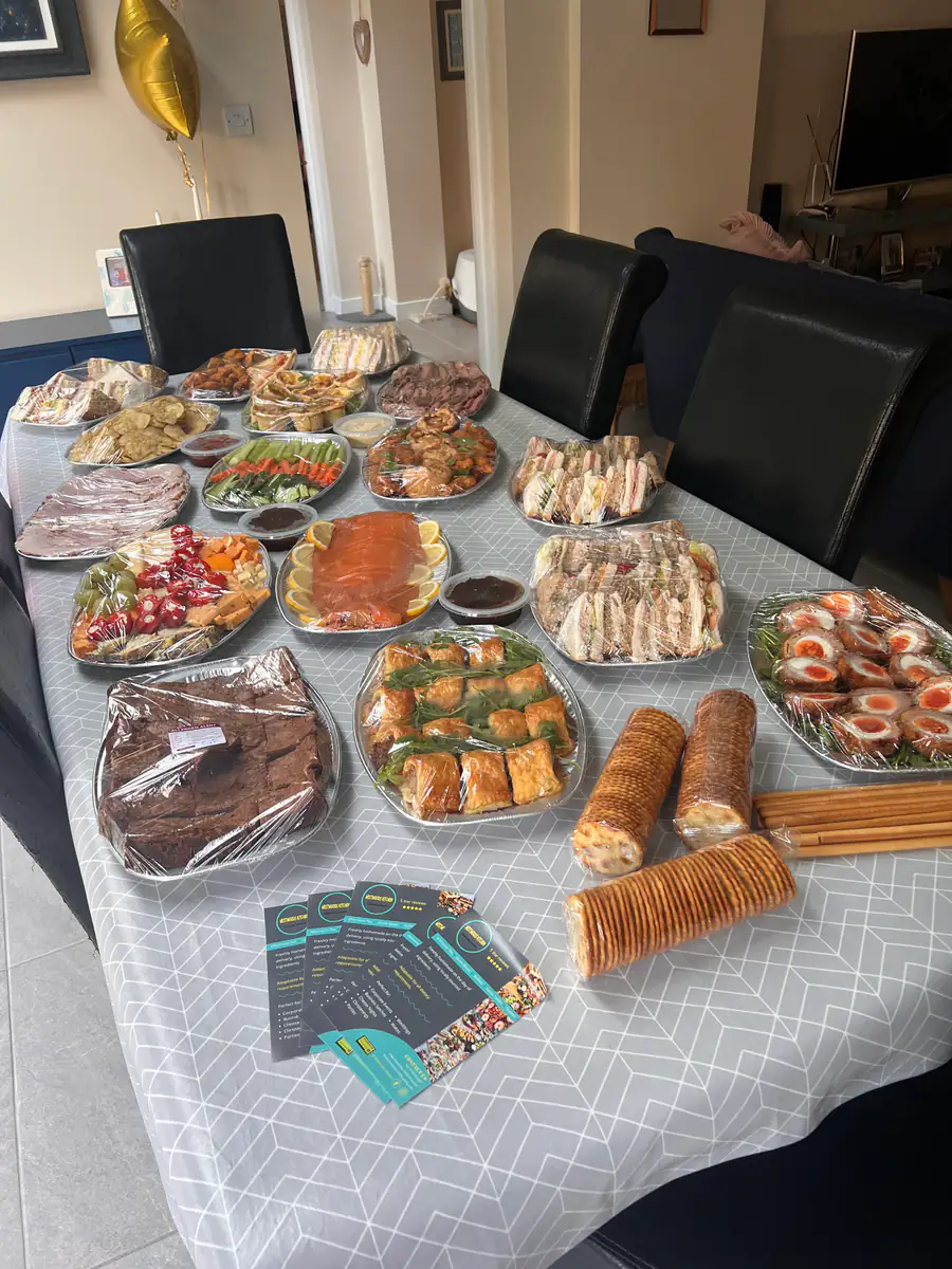 A corporate buffet laid out along a boardroom table with platters and desserts